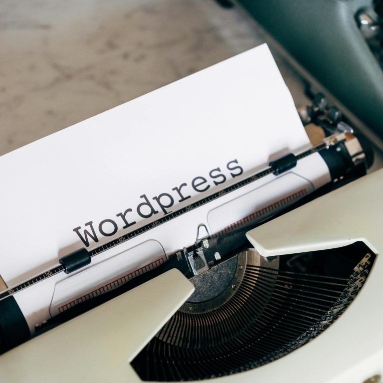 Close-up of a vintage typewriter with 'Wordpress' typed on paper, conveying a classic theme.