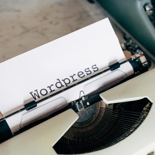 Close-up of a vintage typewriter with 'Wordpress' typed on paper, conveying a classic theme.